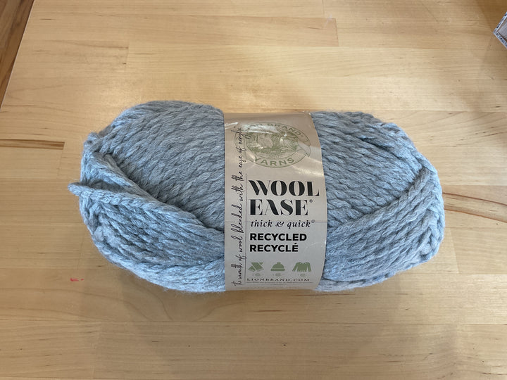 Blue skein of yarn with a label on a wooden surface