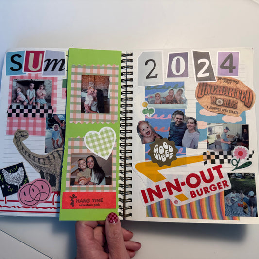 Open spiral-bound notebook with colorful pages featuring photos and text on a white surface.