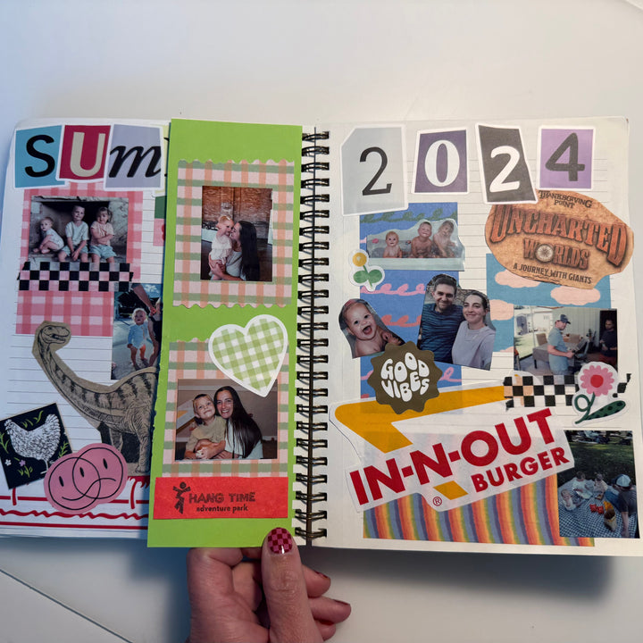 Open spiral-bound notebook with colorful pages featuring photos and text on a white surface.