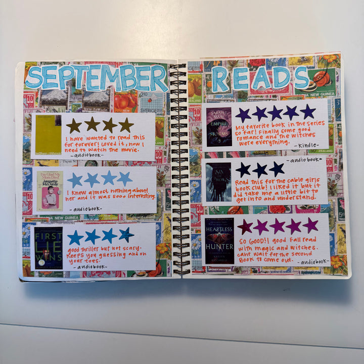 An open spiral-bound journal showing a decorated September reading log with colorful star ratings, handwritten notes, and collage-style headers reading &