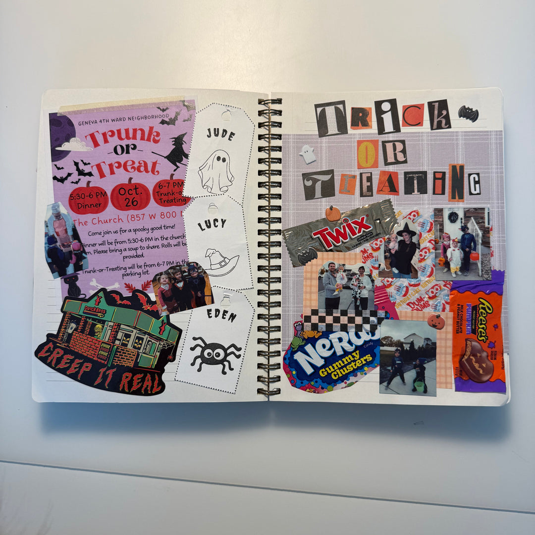 An open spiral notebook showing a Halloween-themed collage spread with stickers, cutout letters, ghost illustrations, candy graphics, and handwritten notes on a white surface.